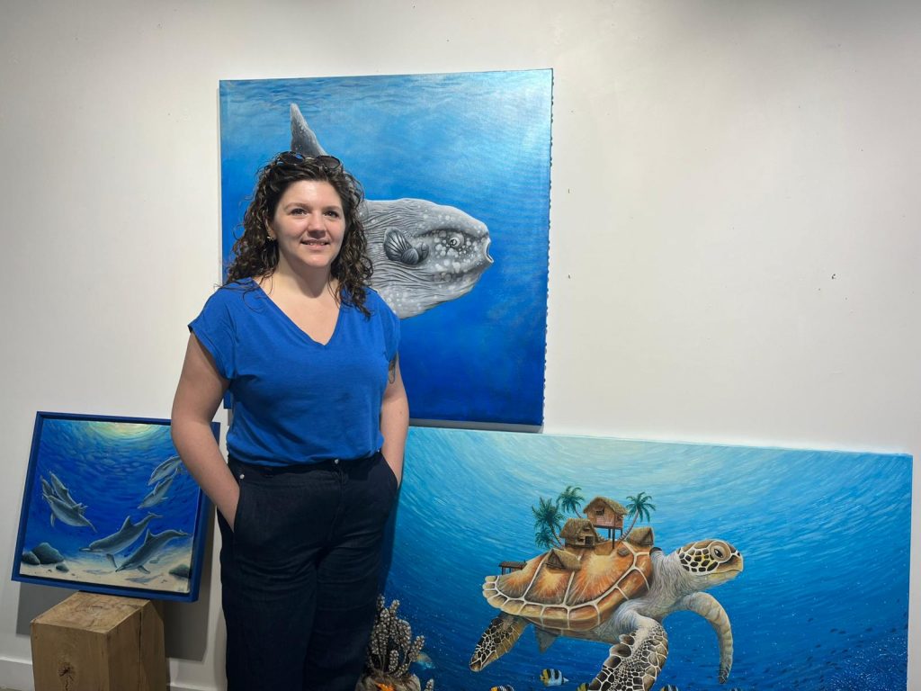 Tiote pose devant deux de ses toiles, quelques heures avant le vernissage de sa première exposition.